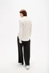Sweater de tejido de punto color negro, con cuello en V y diseño holgado de manga larga.