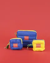 Neceser azul acolchado con cierre amarillo y tirador verde.