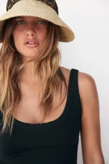 Visor de ala ancha tejido en paja natural, con banda frontal y lazo trasero en tela con estampado de leopardo.