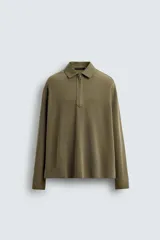 Polo de manga larga con cuello solapa y cierre frontal de cremallera. Presenta un diseño de corte regular con acabado en rib en los puños y un efecto lavado en la tela.