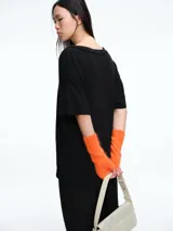 Remera de corte holgado y silueta cómoda, con escote en V y mangas cortas. Presenta costuras visibles en el cuello y los hombros, con un diseño minimalista y versátil.