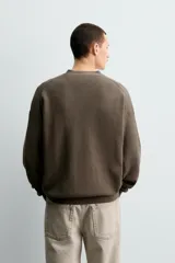 Cárdigan de hombre color negro, de corte regular fit, tejido en estructura compacta, con cuello pico, manga larga y cierre frontal de botonadura.