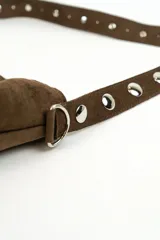 Bolso tipo shopper de gamuza marrón, con asa de hombro ajustable decorada con ojales metálicos plateados y hebilla lateral.