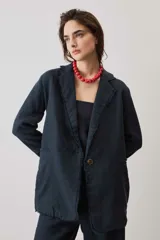 Blazer de lino color azul marino, de corte recto, con solapas y cierre frontal de un botón. Presenta detalles de flecos en los bordes.