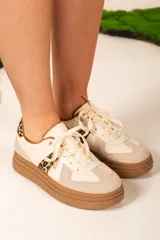 Zapatillas deportivas color blanco y beige con detalles en animal print.