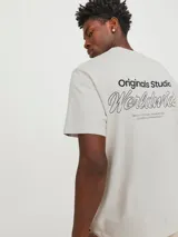 Remera de manga corta color gris claro, de corte relaxed y cuello redondo, con pequeño estampado tipográfico en el pecho.