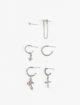 Set de aros plateados con diferentes diseños: un aro tipo pin con detalle rosa, un aro con cadena colgante, dos aros tipo argolla (uno liso y otro texturizado), un aro con dije de hongo multicolor y un aro con dije de cruz.