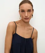 Blusa azul marino de viscosa con textura jacquard floral, escote recto y tirantes finos ajustables. Presenta diseño abullonado tipo globo con frunces que aportan volumen suave.