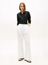 Camisa de lino puro color negro de Tommy Hilfiger, con cuello inglés, manga larga y cierre frontal de botones. Presenta un pequeño logo bordado en el pecho.