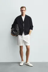 Bermuda regular fit de tejido elástico color blanco, con cintura elástica ajustable mediante cordón, bolsillos delanteros y bolsillos traseros de vivo.
