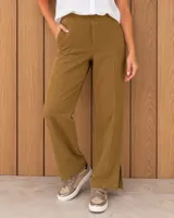 Pantalón largo color mostaza, de corte recto y tiro alto, con costuras frontales en relieve y pequeñas aberturas en el bajo.
