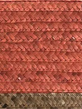 Sobre de mano tipo clutch, confeccionado en fibras naturales color beige con borde tejido en color celeste.