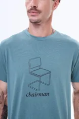 Remera de algodón color verde petróleo, con cuello redondo y estampa frontal de una silla de diseño lineal acompañada por la palabra 'chairman'.