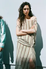 Vestido midi de Zara Woman Collection, con estampado de rayas verticales y detalles ornamentales, escote en V, mangas cortas con aberturas en los hombros, y fajín integrado con lazo lateral del mismo tejido.