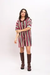 Vestido camisola de tejido de punto fresco con rayas verticales en tonos fucsia, verde oscuro, beige y rosado. Presenta cuello polo marrón, mangas cortas y cierre frontal con botones de madera.