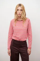 Remera de manga larga con cuello redondo, confeccionada en algodón con diseño de rayas horizontales en tonos rojo y rosado.