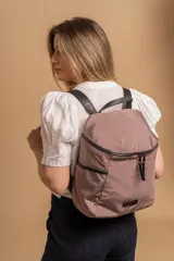 Mochila urbana de diseño compacto en color negro, confeccionada en nylon resistente. Cuenta con un compartimento principal con cierre, bolsillo frontal con cierre y correas ajustables con detalle de marca.