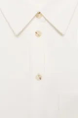 Camisa de corte oversize color marrón, con cuello solapa, mangas anchas por debajo del codo y bolsillo delantero de plastrón. Cierre frontal con botones.