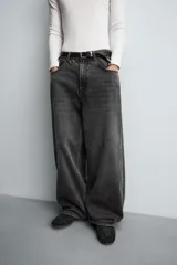 Jeans de denim de algodón, color azul oscuro con efecto lavado. Presentan un corte muy holgado (baggy fit) en toda la pierna y tiro medio. Tienen cinco bolsillos y cierre frontal con cremallera y botón.