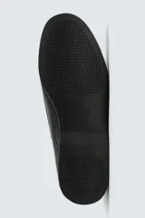 Zapato tipo náutico confeccionado en piel con horma redonda, cordones de piel y suela a tono.