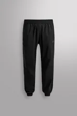 Pantalón jogger negro de corte regular, confeccionado en tejido técnico con algodón. Presenta cintura elástica ajustable con cordón interior, bolsillos laterales y puños elásticos en los tobillos. Posee un pequeño logo estampado en contraste en la pierna derecha.