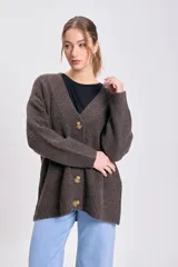 Cardigan de punto en color marrón con escote en V, cierre frontal con botones grandes y mangas largas. Presenta puños y ruedo acanalados.