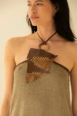 Vestido corto tejido en hilado con brillo visón, con detalle de crochet en contorno y cuello efecto collar en cuero.