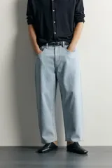 Jeans tapered wide fit de hombre, confeccionados en denim de algodón con efecto lavado en tono azul oscuro. Presentan diseño de cinco bolsillos, tiro medio, corte relajado y cierre frontal con cremallera y botón.