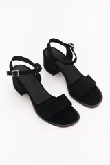 Sandalia de taco cuadrado bajo, confeccionada en gamuza azul, con tira frontal decorada con glitter multicolor y cierre de pulsera con hebilla metálica al tobillo.