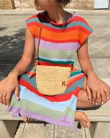 Vestido largo de tejido de punto, con rayas horizontales en tonos tierra, azul y blanco. Presenta cuello redondo, mangas cortas caídas y aberturas laterales en el ruedo.