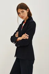 Saco sastrero de denim azul oscuro con costuras a contratono, combinación de forrería en cuerpo y mangas. Tiene botones a tono personalizados en cruce y mangas.