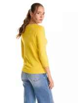 Buzo de tejido fino en color blanco, con cuello redondo y mangas tres cuartos tipo raglán. Presenta un detalle decorativo de tachas metálicas a lo largo de las mangas.