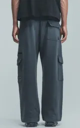 Pantalón de jogging de frisa color gris melange oscuro, con cintura y puños elásticos. Posee dos bolsillos laterales, un bolsillo trasero y un bolsillo lateral adicional con cierre.