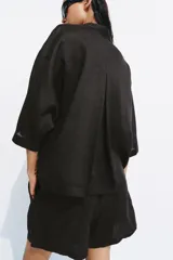 Shorts de tiro medio confeccionados en 100% lino, de color negro. Presentan cintura elástica con volado y cordón ajustable, además de bolsillos delanteros aplicados.