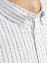 Camisa de vestir de manga larga a rayas verticales finas en tonos celeste y marrón sobre fondo blanco. Tiene cuello abotonado, bolsillo en el pecho y corte slim fit.