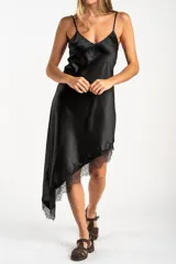 Vestido midi de satén negro con escote en V y tirantes finos. Presenta un diseño asimétrico en el ruedo con detalle de encaje aplicado.