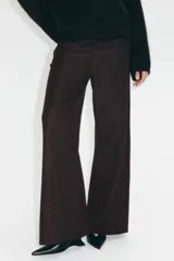 Pantalón amplio de punto bouclé color marrón oscuro, de tiro alto con elástico oculto en la cintura, bolsillos delanteros y cierre con botón.