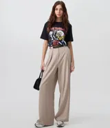 Pantalón de sastrería tipo palazzo color beige, de tiro alto con pinzas delanteras, corte amplio y cierre frontal oculto. Incluye un cinturón fino de poliuretano.