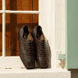 Zapato de cuero color marrón oscuro, con cordones frontales y suela de goma.