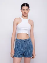 Short de jean azul con textura de roturas, tiro alto, cinco bolsillos, botón y cierre metálico.