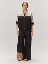 Chaquetas de lino bicolor en tonos blanco y beige, con diseño holgado, cuello alto, cierre frontal de botones, bolsillos con solapa en el pecho y mangas cortas con presilla y botón.