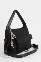 Mochila hobo color marrón claro, convertible en cartera de hombro, confeccionada en nylon. Cuenta con un compartimento principal con cierre, un bolsillo frontal con solapa y cierre de botón a presión, tiras regulables negras y un llavero colgante decorativo con cuentas coloridas y borla.