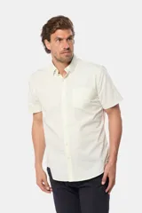 Camisa lisa de manga corta color crema, confeccionada en 100% algodón, con cuello abotonado y un bolsillo en el pecho.