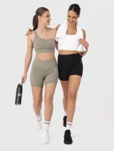 Top deportivo de un solo hombro, color verde, con diseño minimalista y banda elástica inferior para mayor soporte.
