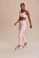 Conjunto deportivo de dos piezas en color rosado, compuesto por una calza larga de tiro alto y un top corto de tirantes finos.