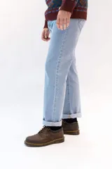 Jean de corte recto clásico con cinco bolsillos, botones de cobre y costuras color camel.