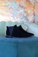Botas de caña corta color negro, de gamuza, con elástico lateral y pequeño taco cuadrado.
