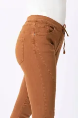 Pantalón de corte skinny color marrón con cintura elastizada y cordón ajustable.