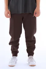 Pantalón de jogging marrón de algodón grueso con interior abrigado, corte amplio, tiro medio, cintura elástica con cordón, bordado mini “vernal” en pierna izquierda, cierres en botamanga para regular el ajuste y detalle de logo V en bordado mini sobre la pantorrilla.
