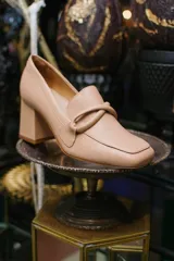 Zapato de cuero rojo con aplique decorativo en el empeine y tacón cuadrado.